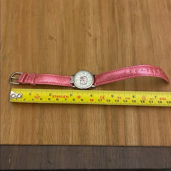 This is a Hello Kitty analog watch with a sparkly pink band and a jeweled bow - Picture 4 of 7